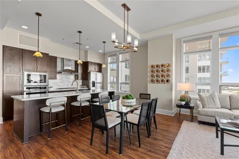 a kitchen with stainless steel appliances a dining table chairs stove and refrigerator