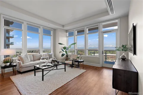 a living room with furniture flat screen tv and a large window