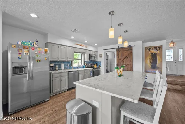 a kitchen with refrigerator and chairs