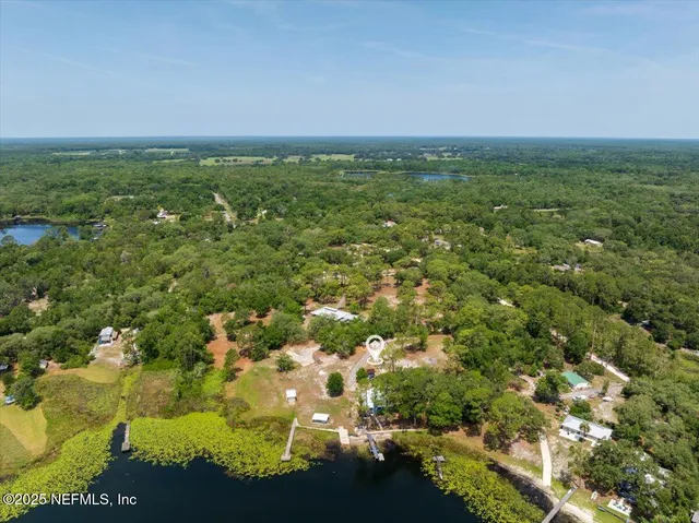 an aerial view of residential houses with outdoor space and trees