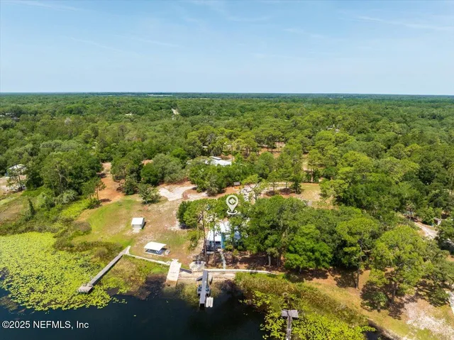 an aerial view of residential houses with outdoor space and trees
