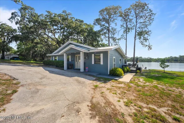 a view of a house with backyard and trees
