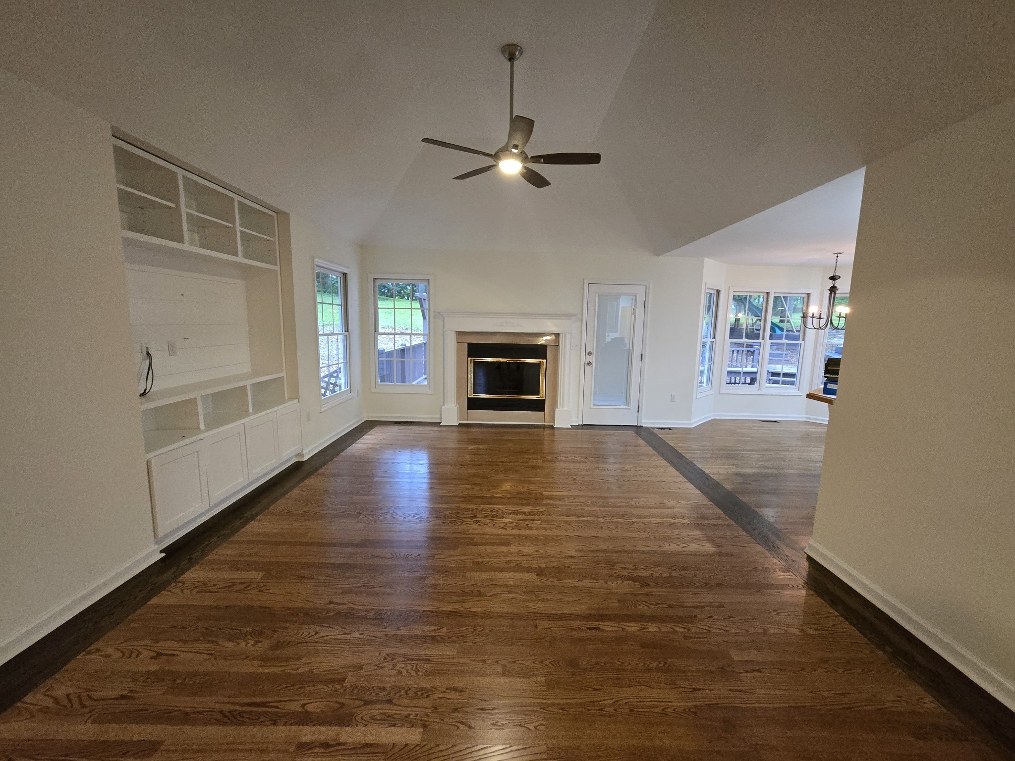 449 Faith-Rae Boulevard Morrison, TN 37357 - Photo 2 of 12 an empty room with wooden floor fireplace and windows
