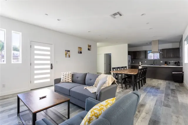 a living room with furniture kitchen view and a window
