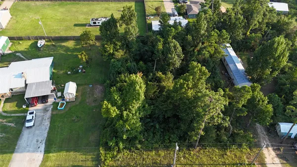an aerial view of residential houses with outdoor space and trees