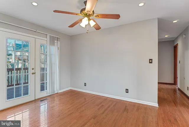 a view of a room with wooden floor and a ceiling fan