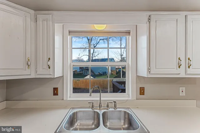 a kitchen with stainless steel appliances granite countertop a sink and a white cabinets