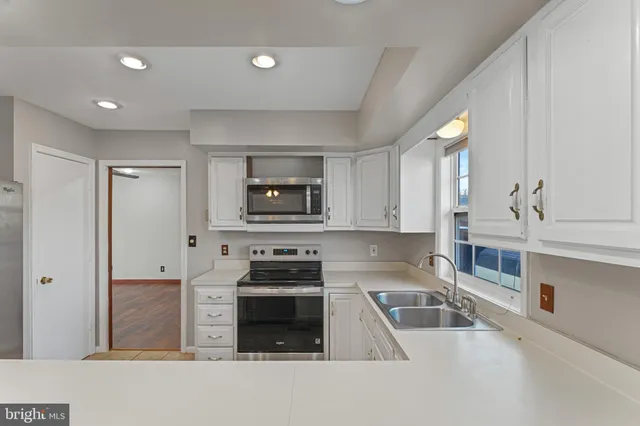 a kitchen with stainless steel appliances a sink a stove and a refrigerator