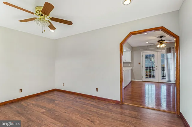 a view of a room with wooden floor and a ceiling fan
