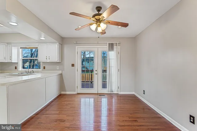 a view of a kitchen with a sink dishwasher a refrigerator with wooden floor