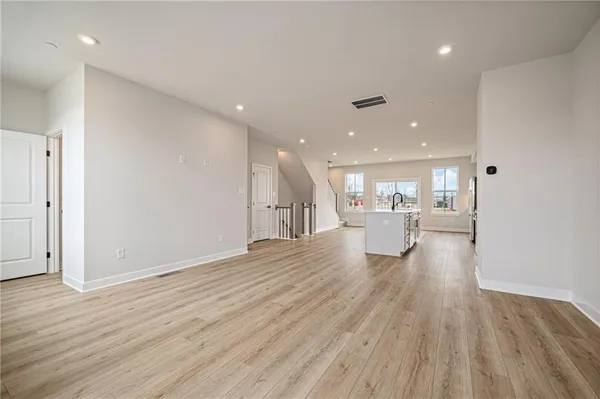 a view of a living room and a kitchen with wooden floor