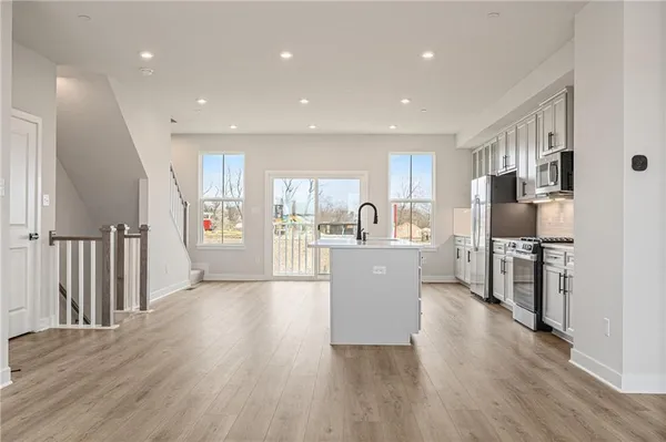 a kitchen with wooden floors and white cabinets
