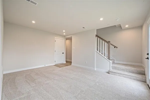 an empty room with stairs and white walls