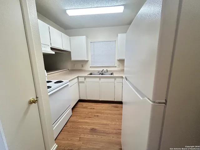 a kitchen with a sink a refrigerator and cabinets