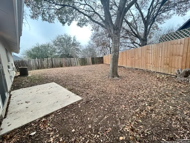 a view of backyard with wooden fence
