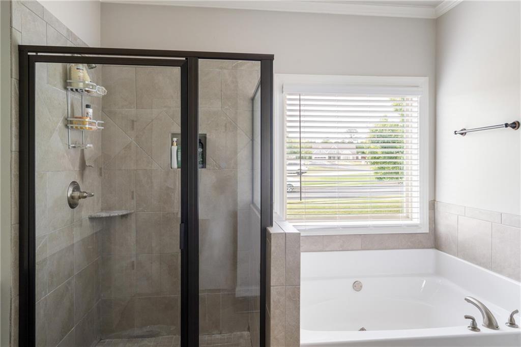 712 Fleeting Way Monroe, GA 30655 - Photo 17 of 29 a bathroom with a bathtub and a shower
