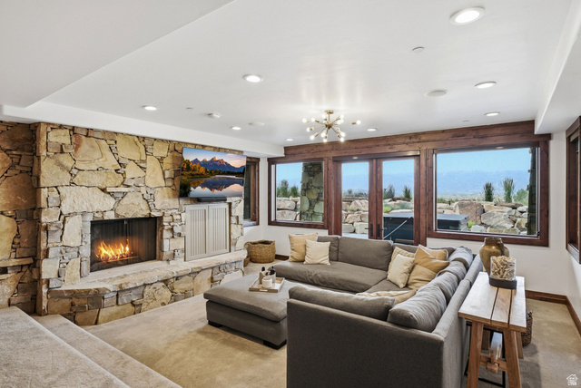7885 North Rabbitbrush Court, Unit 13 Park City, UT 84098 - Photo 37 of 88 Great room featuring a full-height stone-faced fireplace with a stone hearth, wood-finish window trim, multiple recessed ceiling lights, and a contemporary ceiling fixture