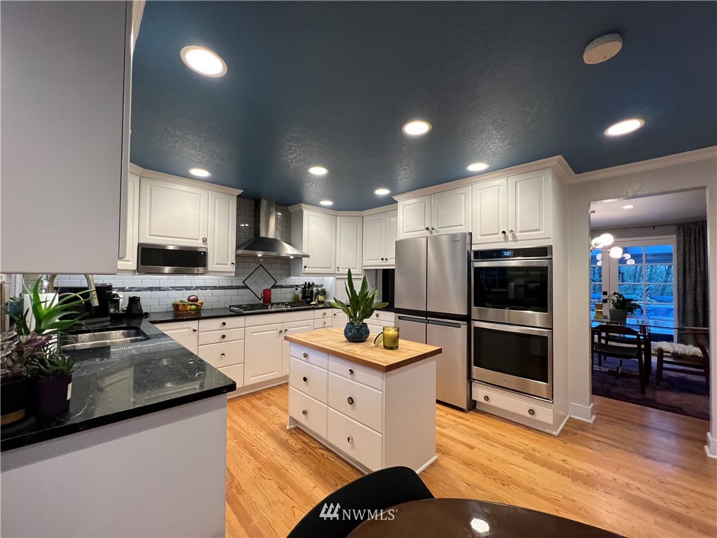 718 222nd Street Southwest Bothell, WA 98021 - Photo 5 of 22 a kitchen with stainless steel appliances kitchen island granite countertop a refrigerator and a stove top oven
