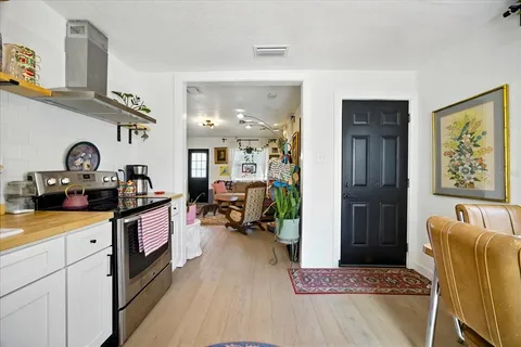 a kitchen that has a lot of cabinets a sink and wooden floor