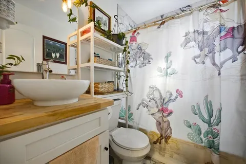 a bathroom with a granite countertop sink and a toilet