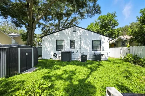 a backyard of a house with table and chairs