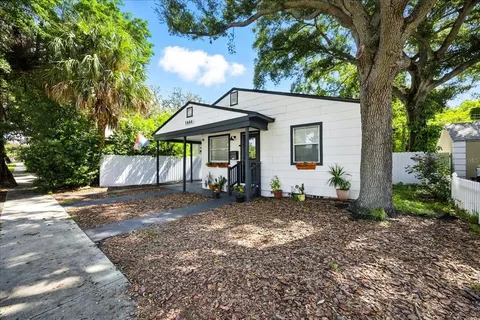 a view of a house with backyard and chairs