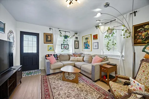 a living room with furniture a flat screen tv and a window