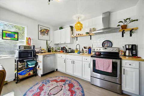 a kitchen with stove and cabinets