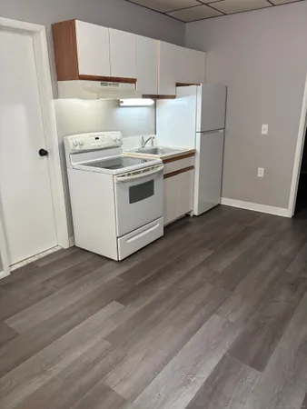 a utility room with wooden floor washer and dryer