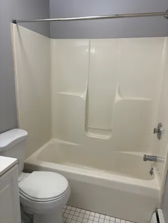 a white toilet sitting next to a bath tub
