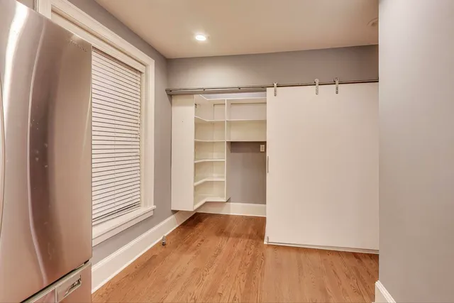 a view of walk in closet with empty racks