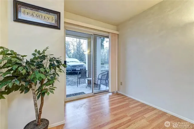 an entryway with wooden floor and a potted plant