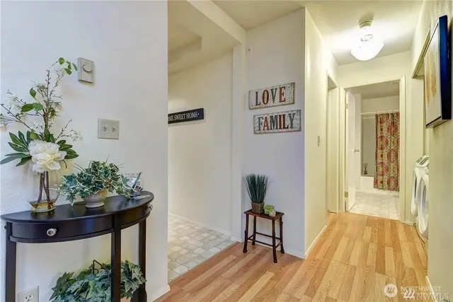 a view of a hallway with wooden floor and a potted plant