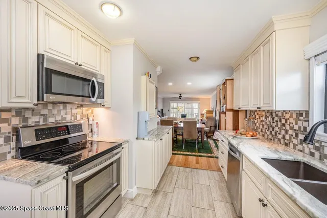 a kitchen with stainless steel appliances a stove sink microwave and cabinets