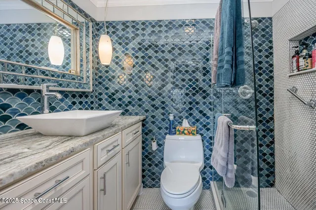 a bathroom with a granite countertop toilet sink and mirror