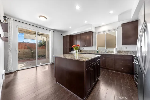 a kitchen with stainless steel appliances granite countertop a sink a stove and a refrigerator