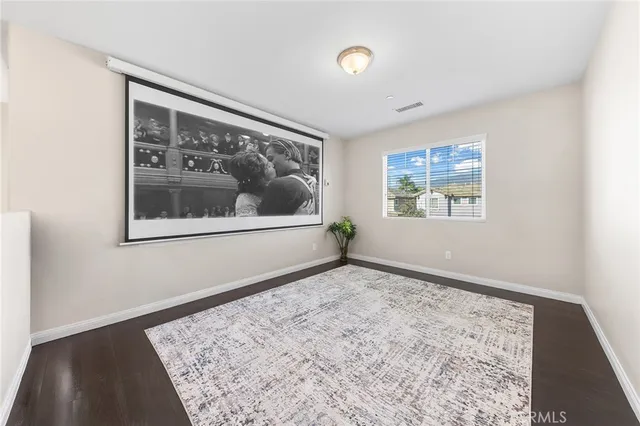 a view of a big room with wooden floor and windows