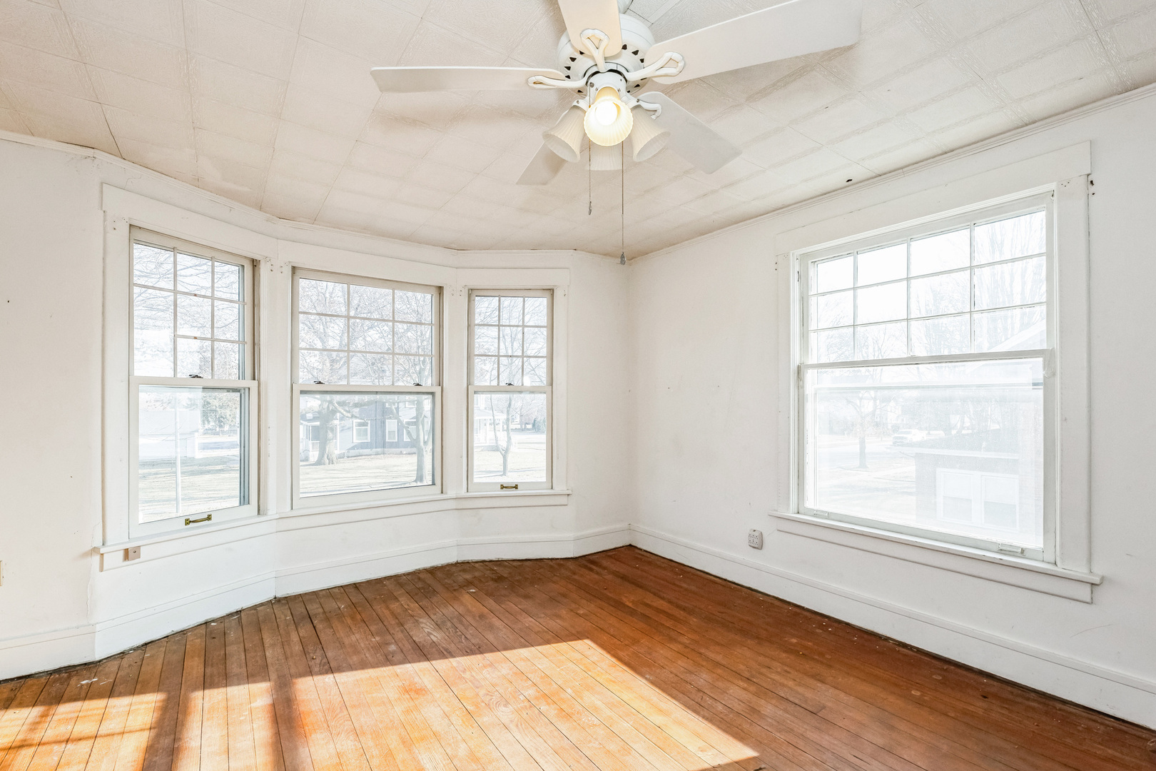 710 North 7th Street Rochelle, IL 61068 - Photo 17 of 32 an empty room with wooden floor fan and windows
