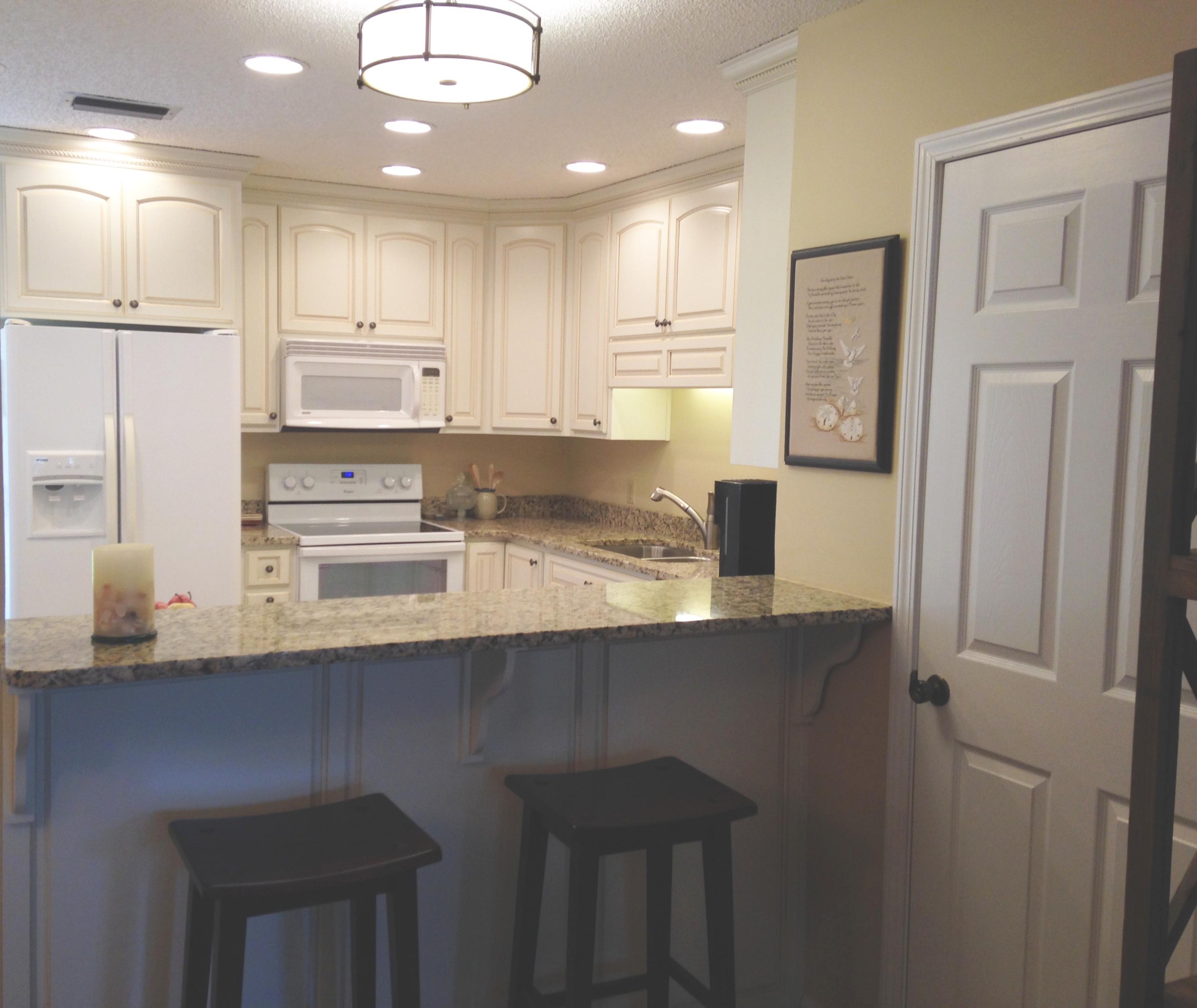 241 Ellis Road, Unit 6 Miramar Beach, FL 32550 - Photo 5 of 30 a kitchen with kitchen island granite countertop a sink cabinets and stainless steel appliances
