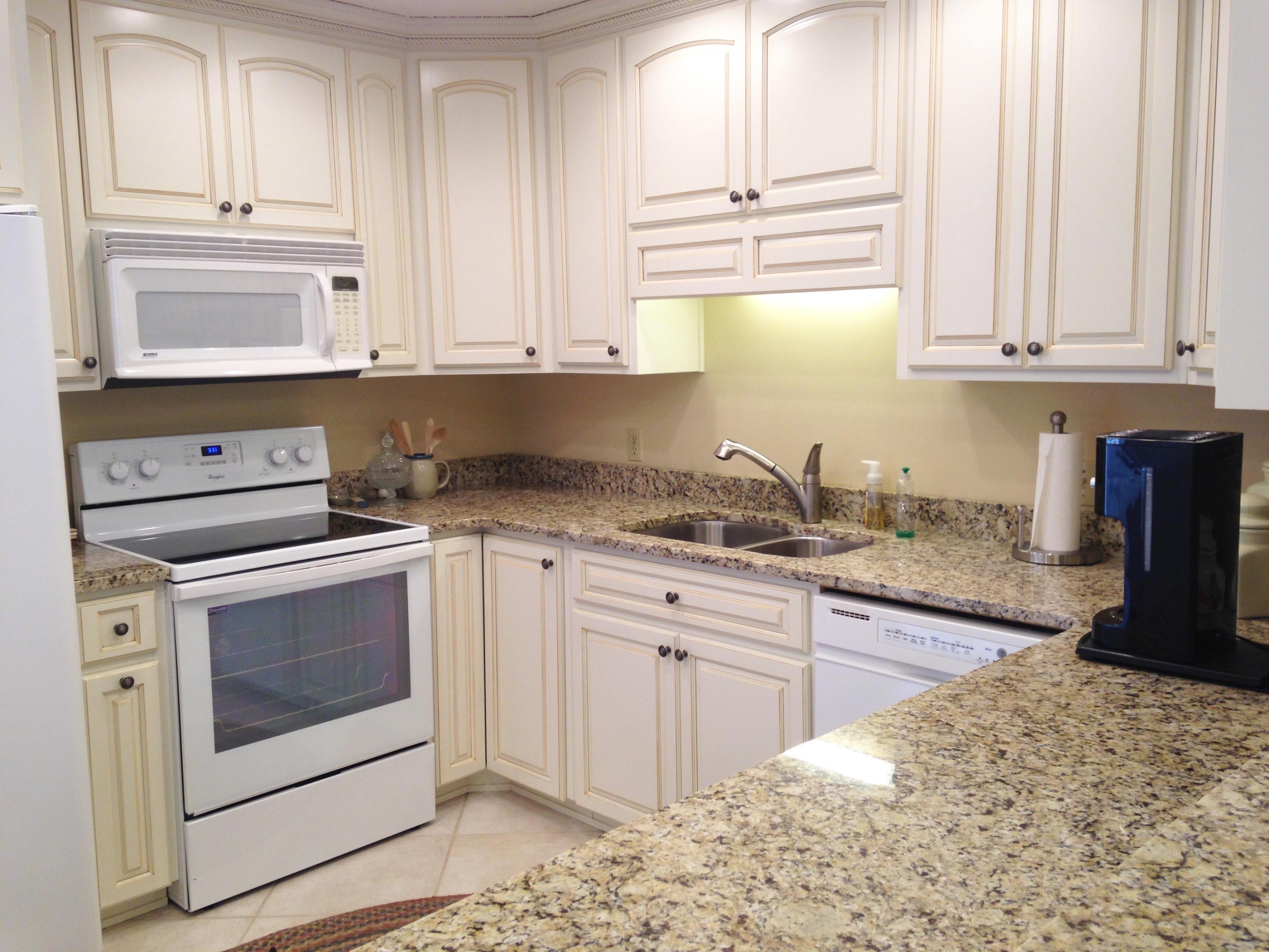 241 Ellis Road, Unit 6 Miramar Beach, FL 32550 - Photo 6 of 30 a kitchen with granite countertop white cabinets and white appliances