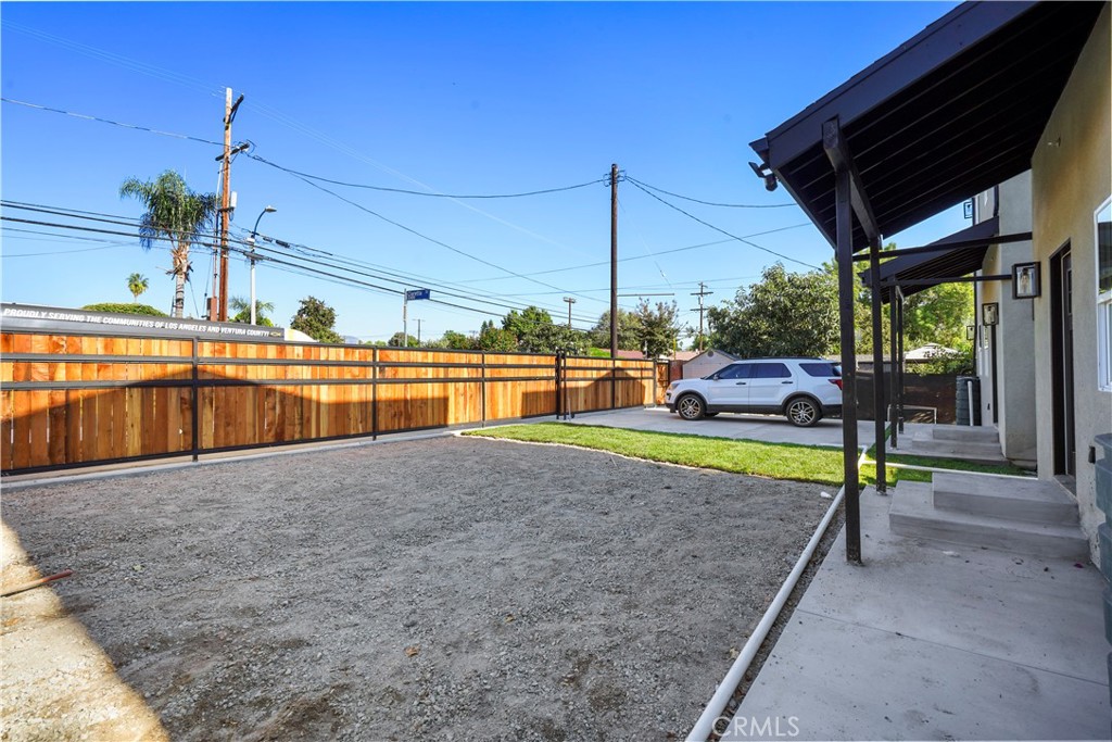 11531 Dronfield Avenue Pacoima, CA 91331 - Photo 11 of 12 a view of a backyard with lawn chairs under an umbrella