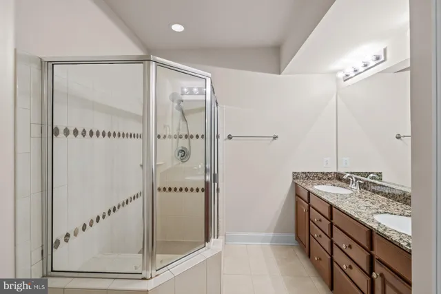 a bathroom with a granite countertop sink shower and a mirror