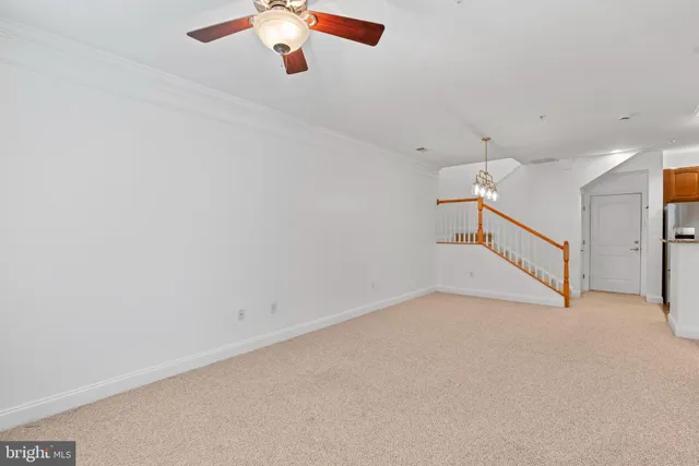 an empty room with a ceiling fan and window