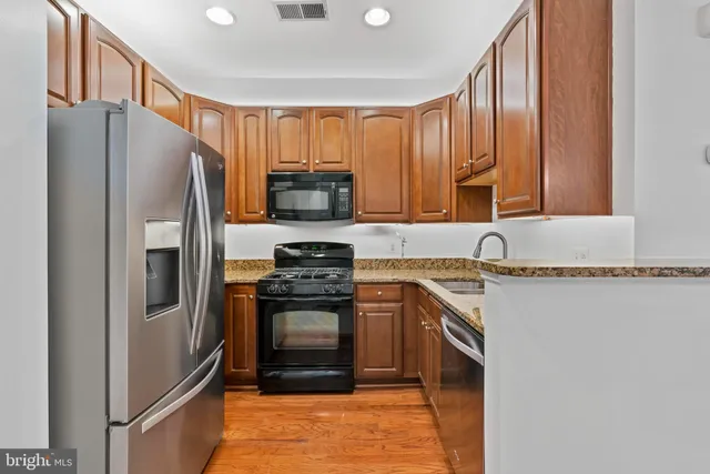 a kitchen with stainless steel appliances granite countertop a refrigerator stove and sink