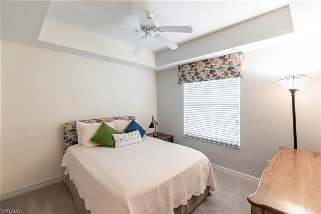 451 Bayfront Place, Unit 5309 Naples, FL 34102 - Photo 23 of 33 Bedroom featuring a tray ceiling, carpet floors, and a ceiling fan