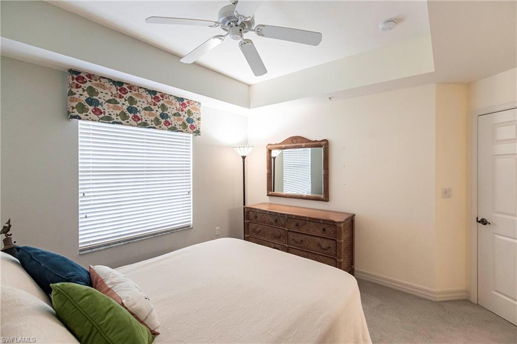 451 Bayfront Place, Unit 5309 Naples, FL 34102 - Photo 24 of 33 Bedroom with light colored carpet, ceiling fan, and a tray ceiling