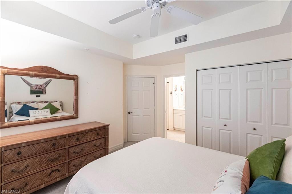 451 Bayfront Place, Unit 5309 Naples, FL 34102 - Photo 25 of 33 Bedroom featuring a raised ceiling, a closet, and a ceiling fan