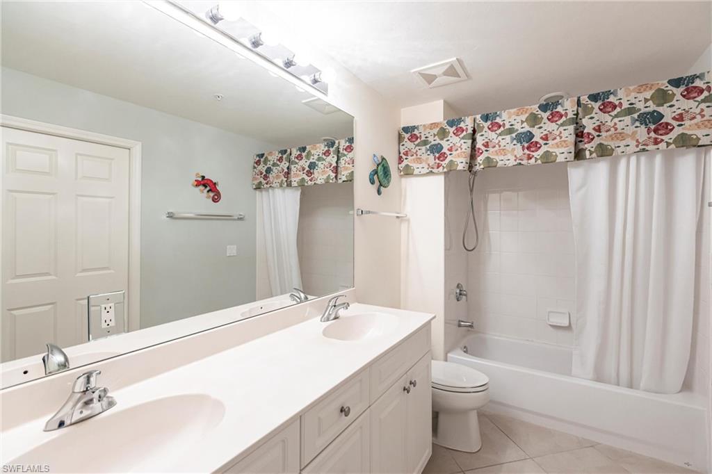 451 Bayfront Place, Unit 5309 Naples, FL 34102 - Photo 27 of 33 Bathroom featuring shower / bathtub combination with curtain, light tile patterned floors, and double vanity