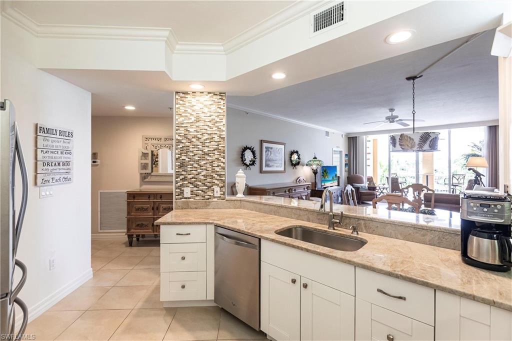 451 Bayfront Place, Unit 5309 Naples, FL 34102 - Photo 9 of 33 Kitchen featuring ornamental molding, light stone countertops, light tile patterned floors, white cabinetry, and stainless steel appliances