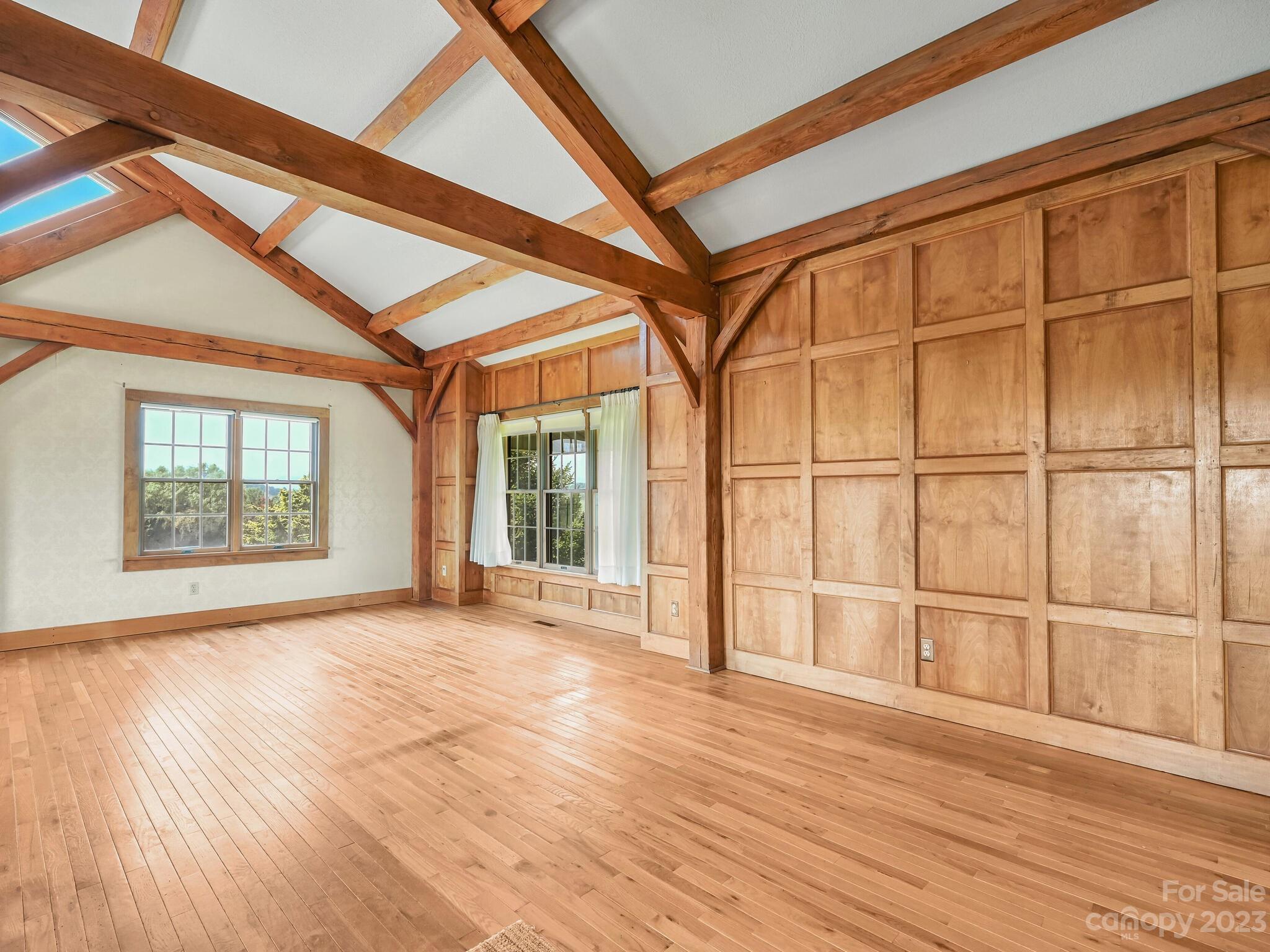 386 Heather Downs Drive Alexander, NC 28701 - Photo 11 of 29 an empty room with wooden floor and windows